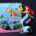 Action figure Principessa Ariel La Sirenetta Disney alta 19 cm con capelli rossi fluenti, coda di sirena scintillante e conchiglia viola, plastica resistente con licenza ufficiale
